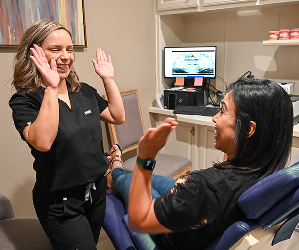 Orthodontic Assistant and Patient high-fiving.